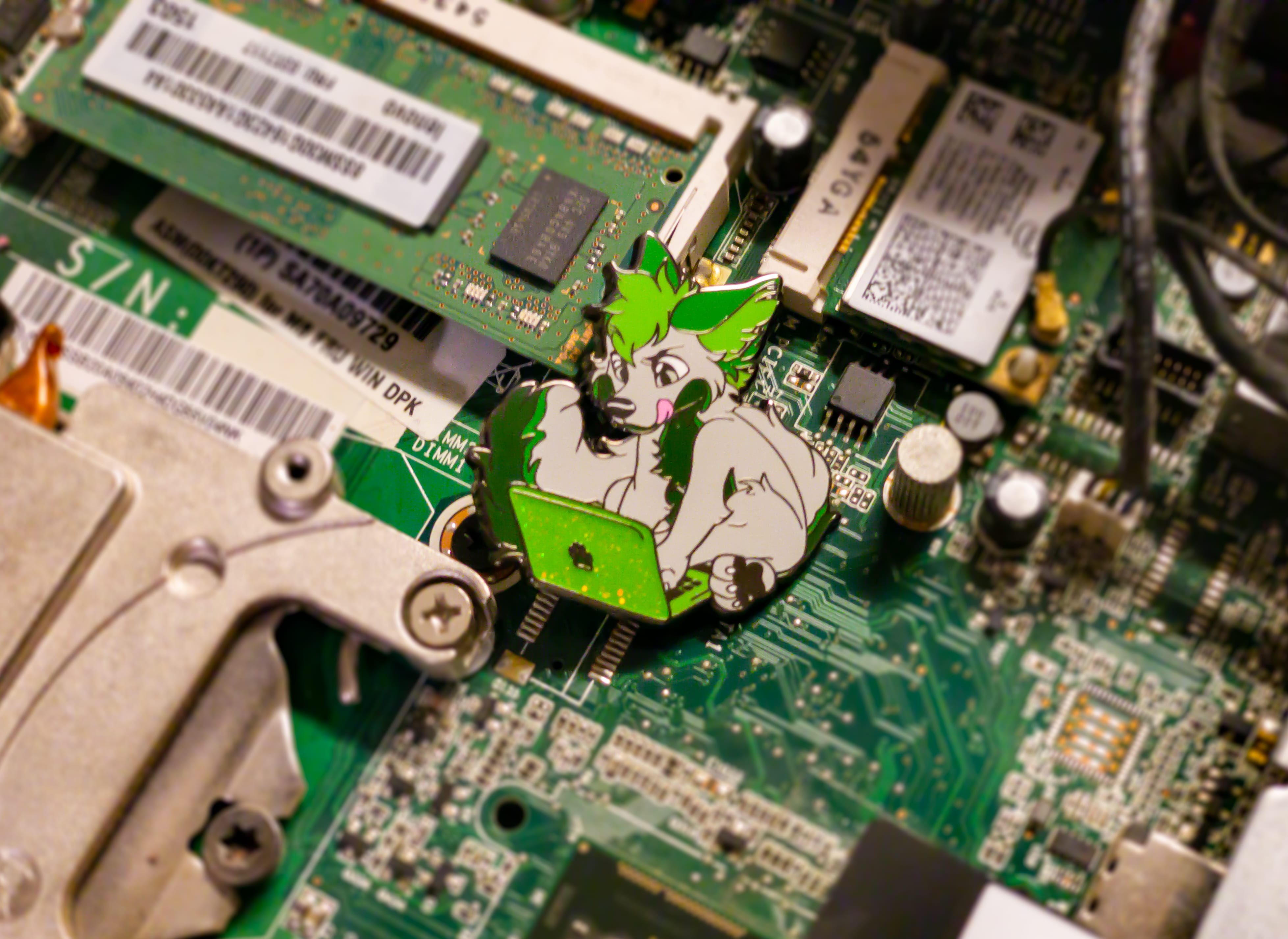 The pin at home inside a computer. Laptop lid and pawprint color will match the chosen variant, not the one pictured here!
